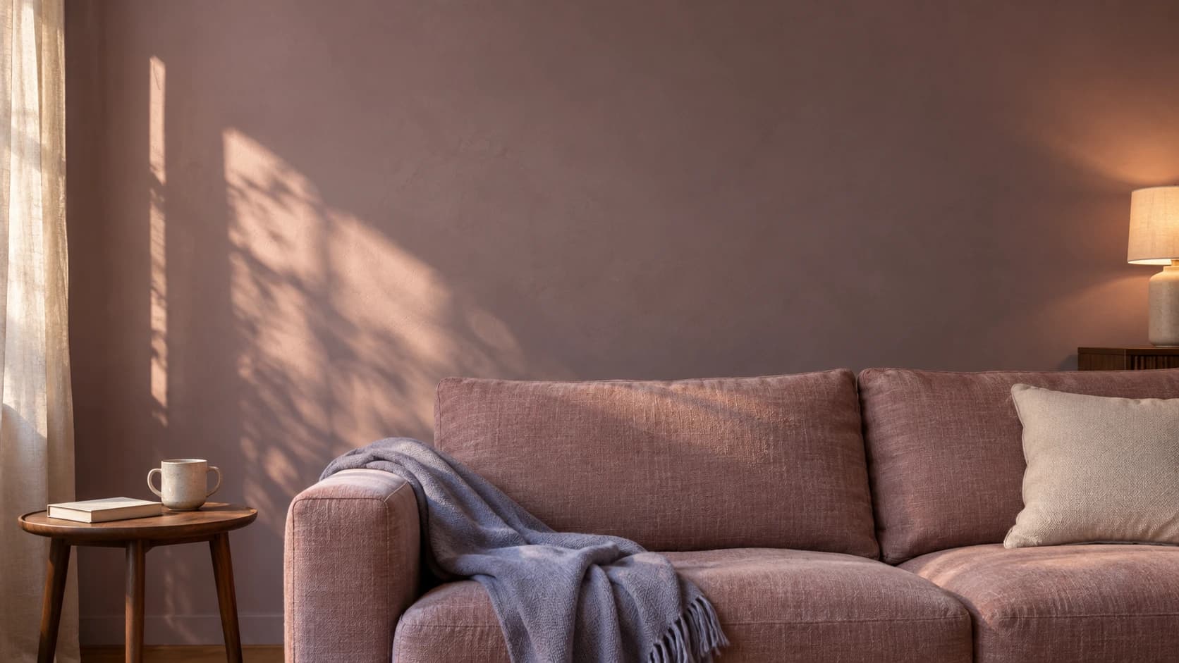 A soft rose couch with a lavender throw in warm afternoon light.